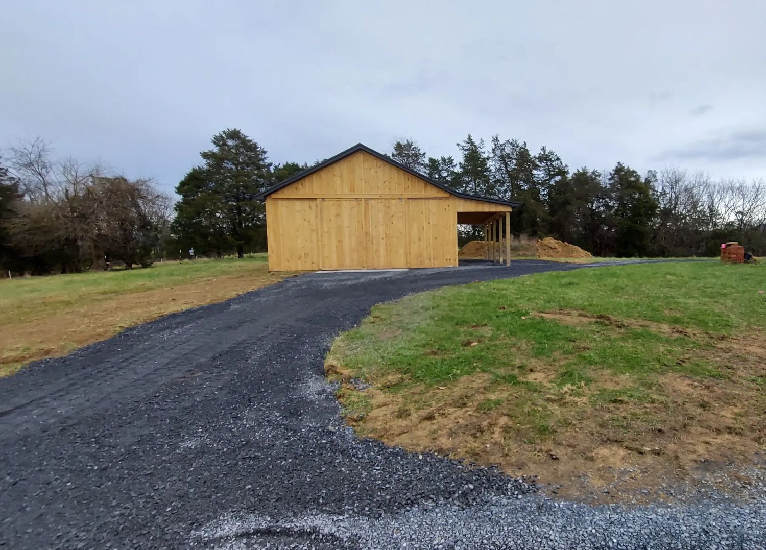 gravel driveway up to wood building